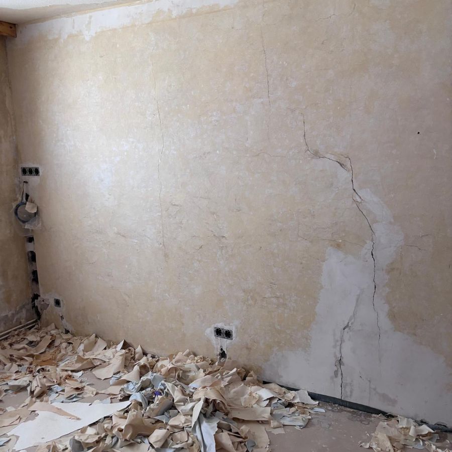 Wand nach dem Entfernen alter Tapeten, vor der Spachtelung