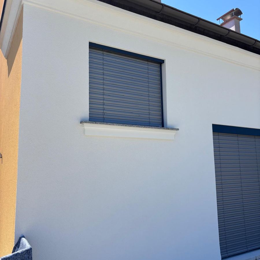 Neue weiße Fassade eines Einfamilienhauses nach der Erneuerung